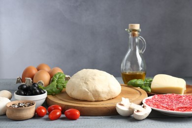 Photo of Making pizza. Different ingredients on gray wooden table