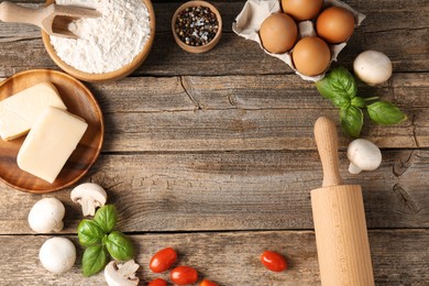 Photo of Making pizza. Different ingredients on wooden table, flat lay. Space for text
