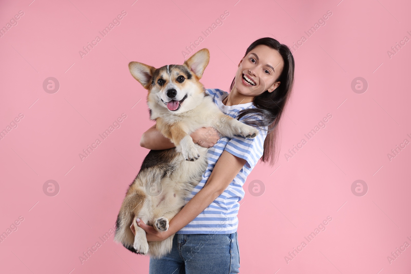 Photo of Animal training. Woman with her cute dog on pink background