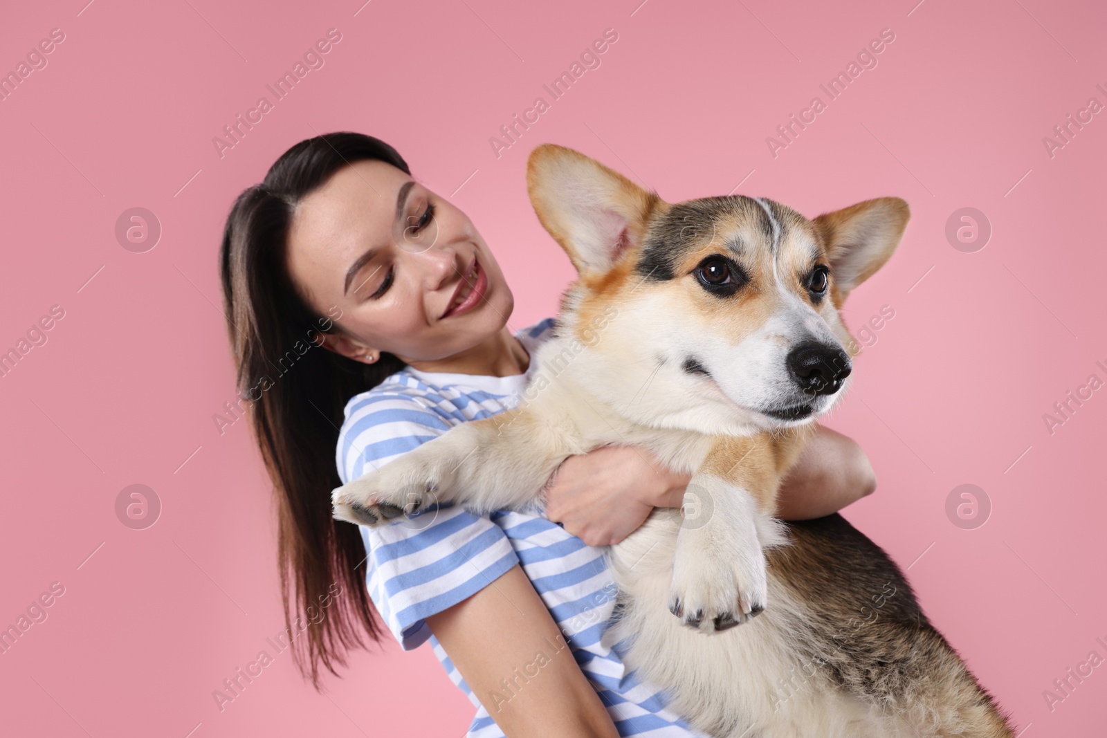 Animal training. Woman with her cute dog on pink background Photo of Animal training. Woman with her cute dog on pink background