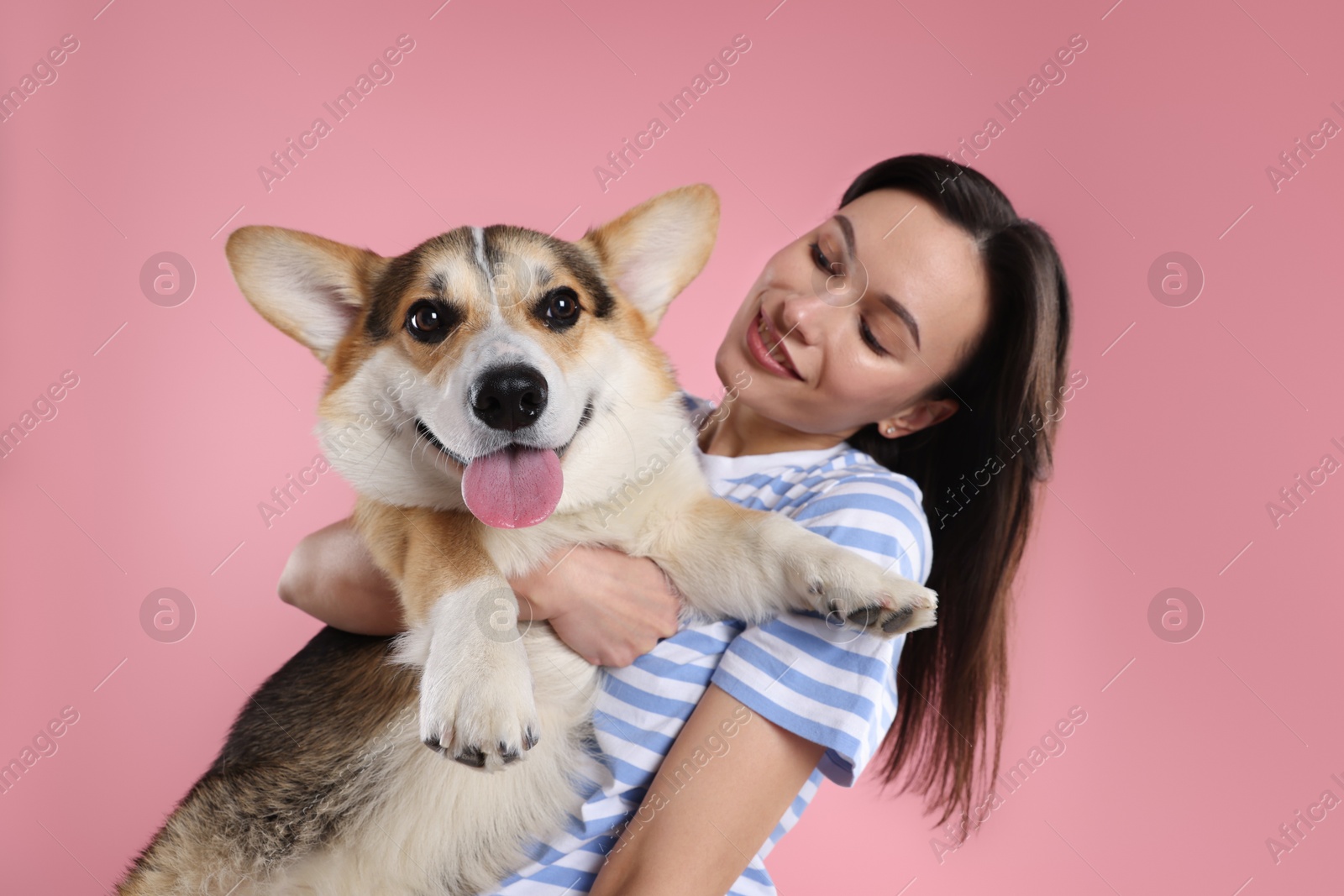 Photo of Animal training. Woman with her cute dog on pink background
