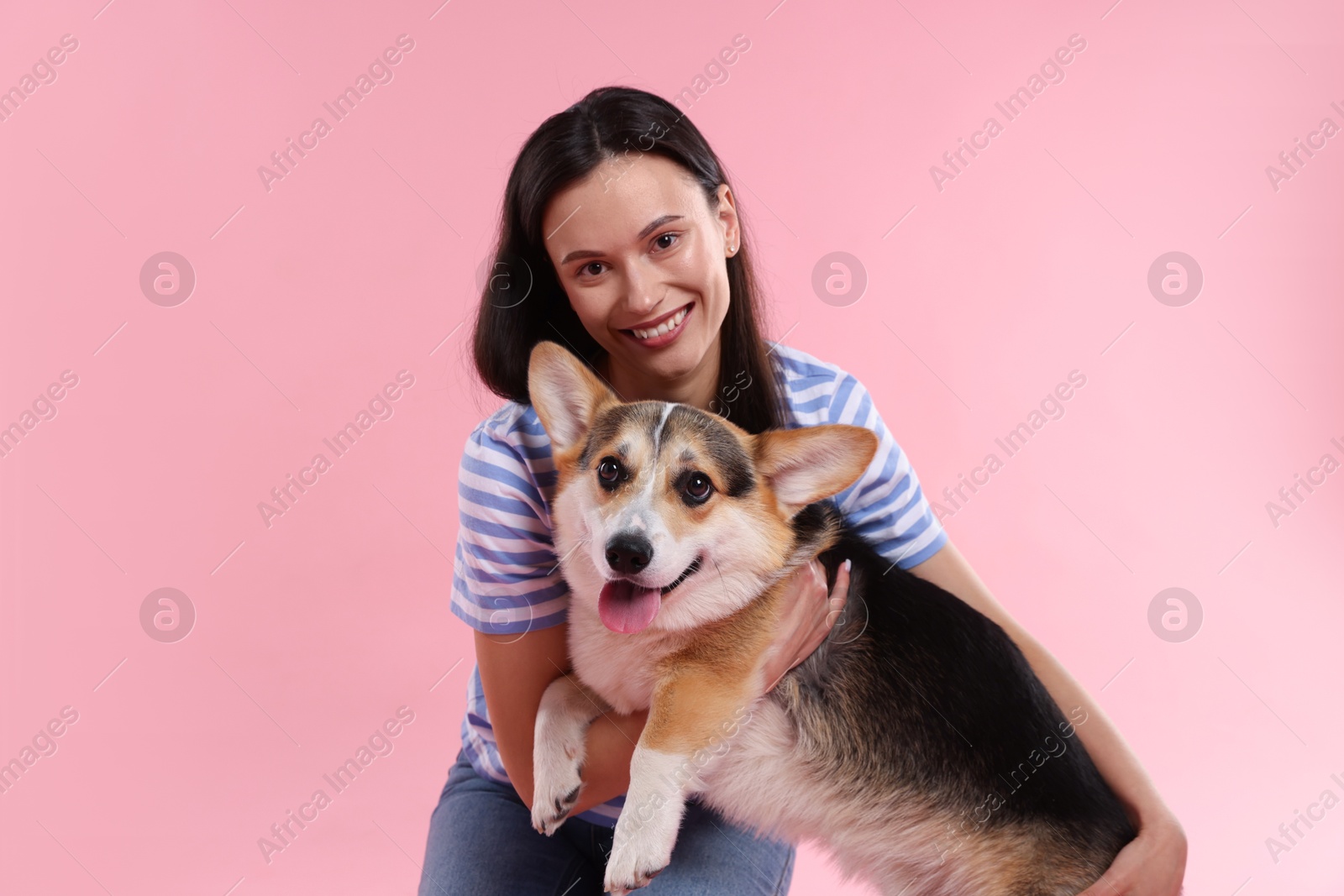 Photo of Animal training. Woman with her cute dog on pink background