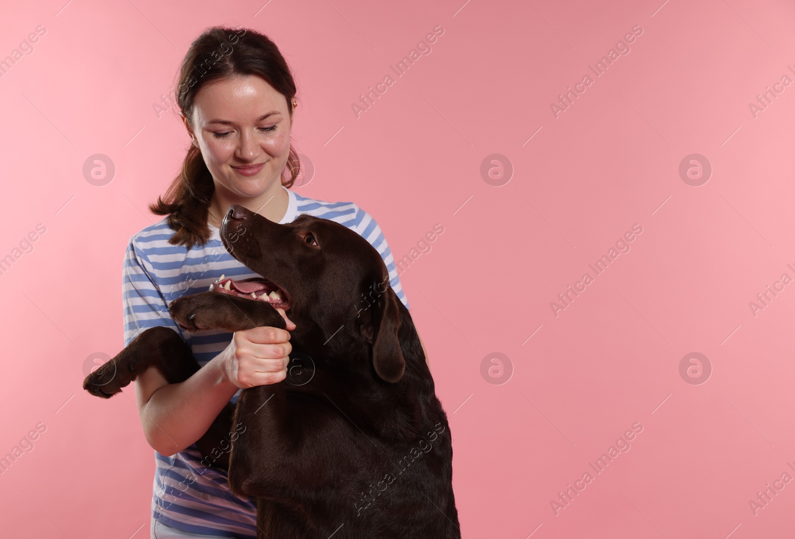 Animal training. Woman with her cute dog on pink background, space for text Photo of Animal training. Woman with her cute dog on pink background, space for text