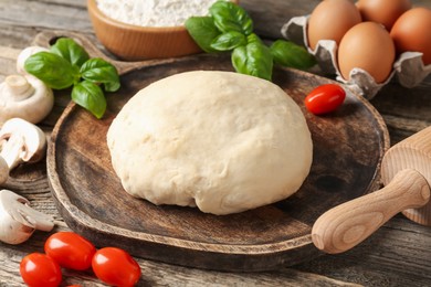 Photo of Making pizza. Different ingredients on wooden table, closeup