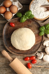 Photo of Making pizza. Different ingredients on wooden table, flat lay