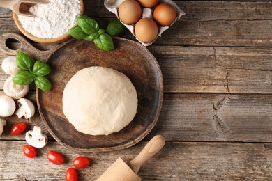 Photo of Making pizza. Different ingredients on wooden table, flat lay. Space for text