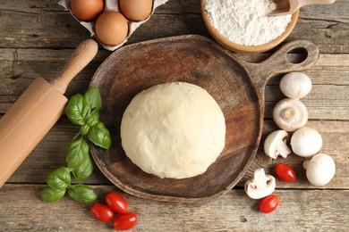 Photo of Making pizza. Different ingredients on wooden table, flat lay