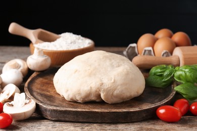 Photo of Making pizza. Different ingredients on wooden table, closeup