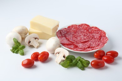 Photo of Making pizza. Different ingredients isolated on white