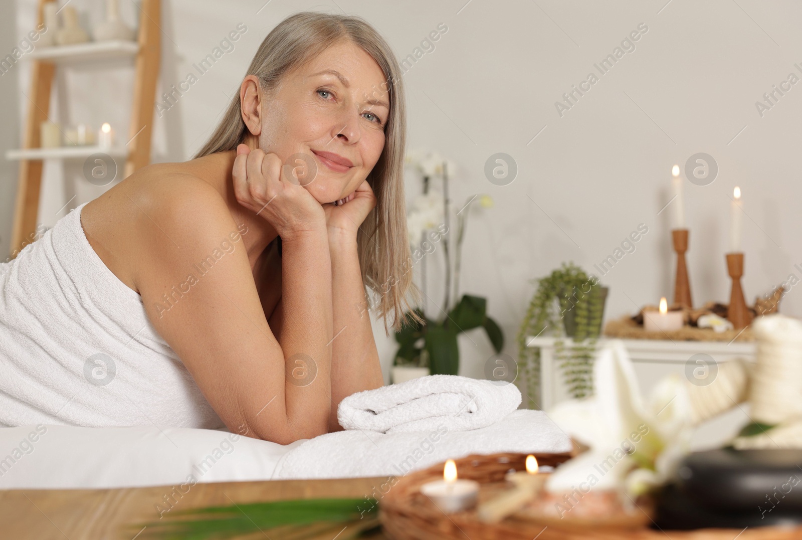 Senior woman relaxing on massage couch in spa salon Photo of Senior woman relaxing on massage couch in spa salon