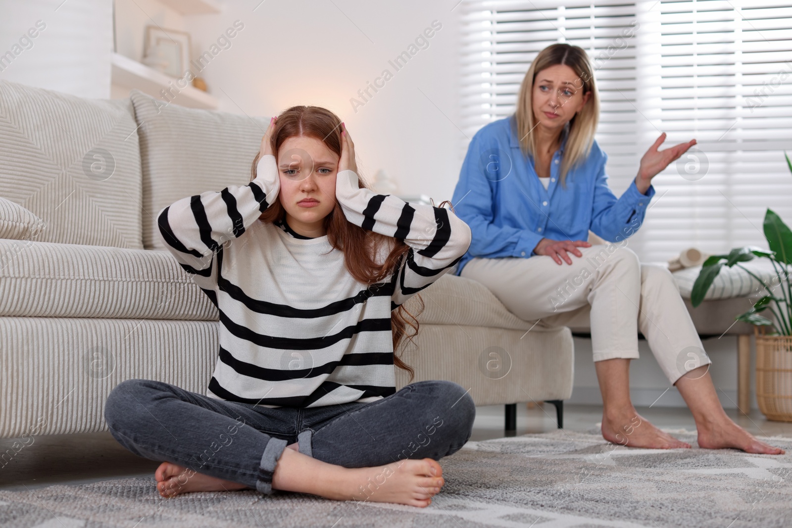 Teenage daughter ignoring her mother at home, selective focus Photo of Teenage daughter ignoring her mother at home, selective focus