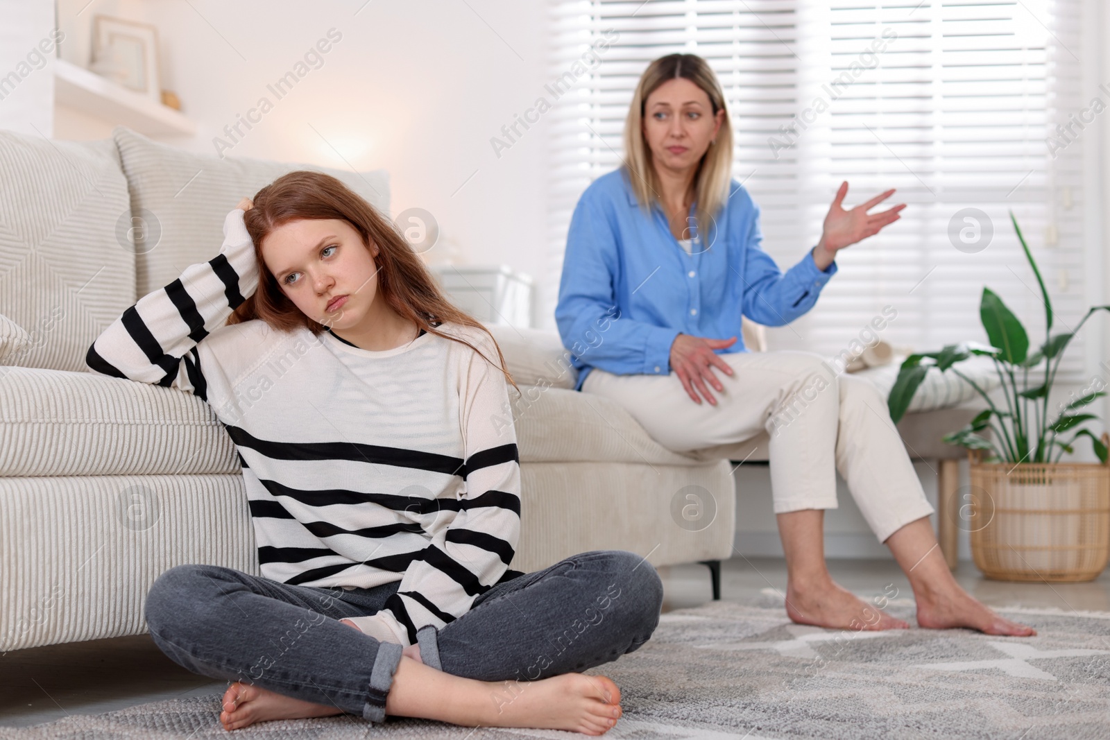Teenage daughter ignoring her mother at home, selective focus Photo of Teenage daughter ignoring her mother at home, selective focus