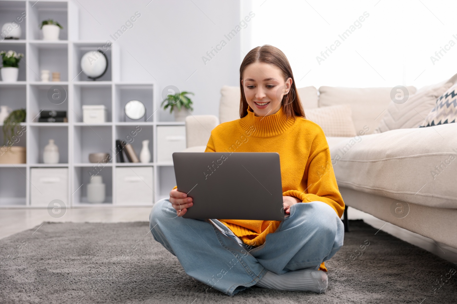 Photo of Teenage girl with laptop on floor at home, space for text