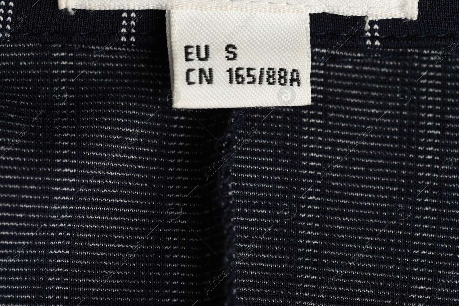 Clothing label on black garment as background, closeup Photo of Clothing label on black garment as background, closeup
