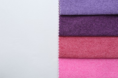 Photo of Samples of different fabrics on white background, top view. Space for text