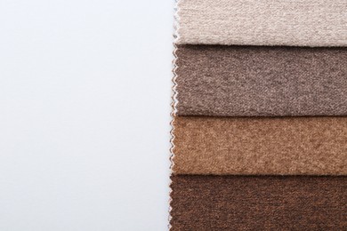 Photo of Samples of different fabrics on white background, top view. Space for text