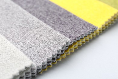 Photo of Samples of different fabrics on white background, closeup. Space for text