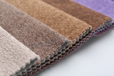 Photo of Samples of different fabrics on white background, closeup. Space for text