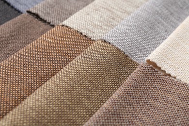 Photo of Samples of different fabrics as background, closeup