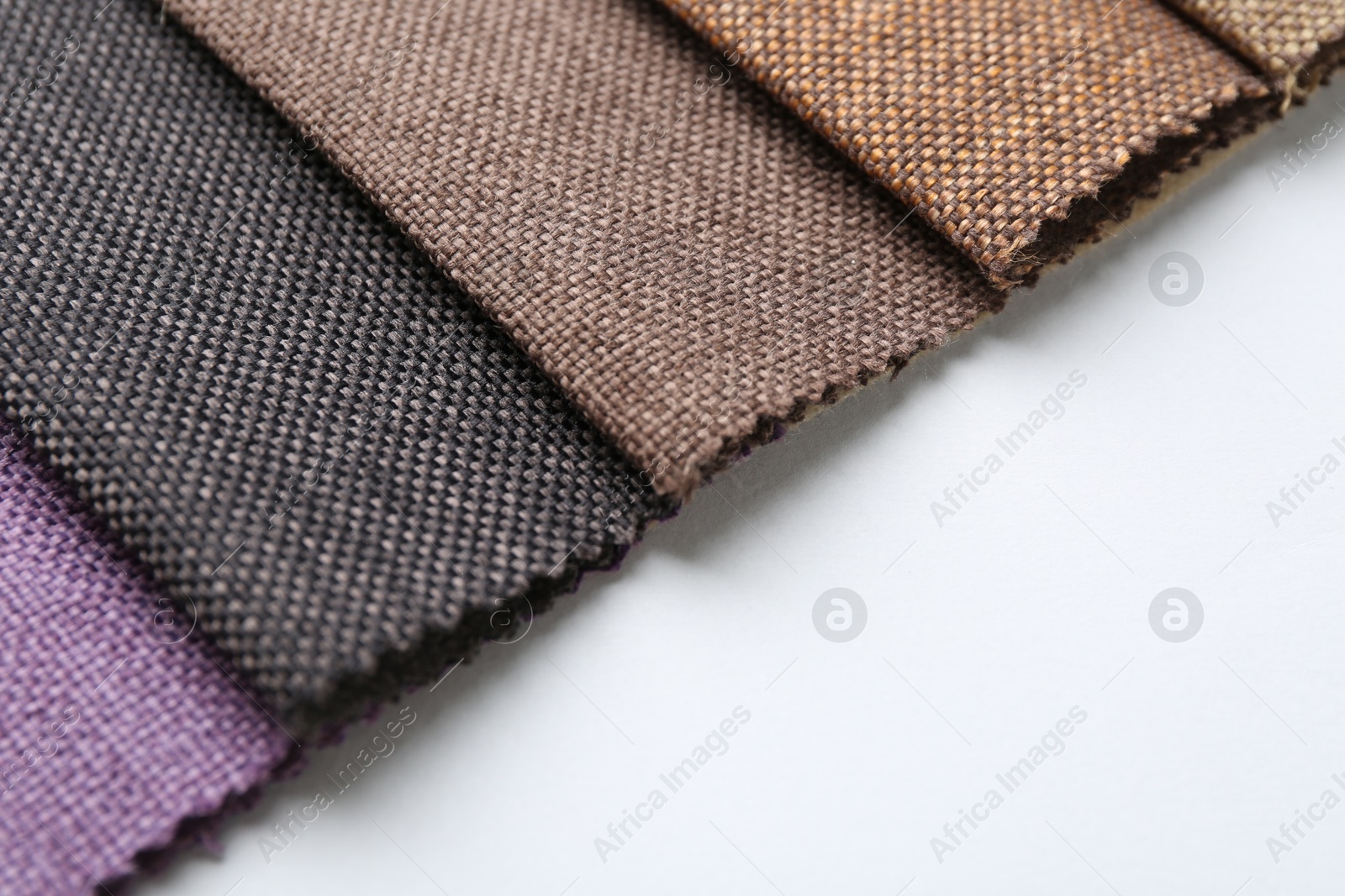 Samples of different fabrics on white background, closeup. Space for text Photo of Samples of different fabrics on white background, closeup. Space for text