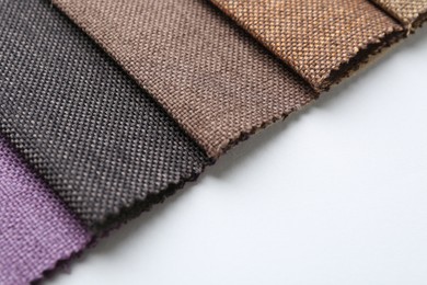 Photo of Samples of different fabrics on white background, closeup. Space for text