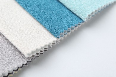 Photo of Samples of different fabrics on white background, closeup. Space for text