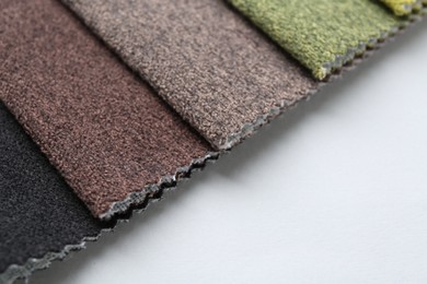 Photo of Samples of different fabrics on white background, closeup. Space for text