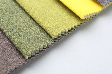 Photo of Samples of different fabrics on white background, closeup. Space for text
