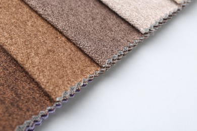 Photo of Samples of different fabrics on white background, closeup. Space for text