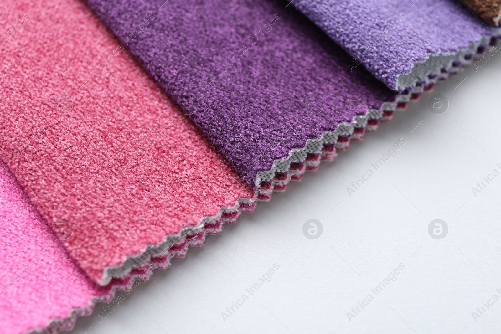 Samples of different fabrics on white background, closeup. Space for text Photo of Samples of different fabrics on white background, closeup. Space for text