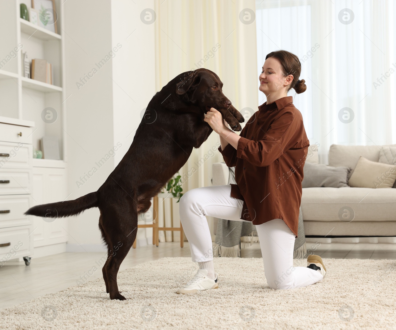 Beautiful woman training her dog at home Photo of Beautiful woman training her dog at home