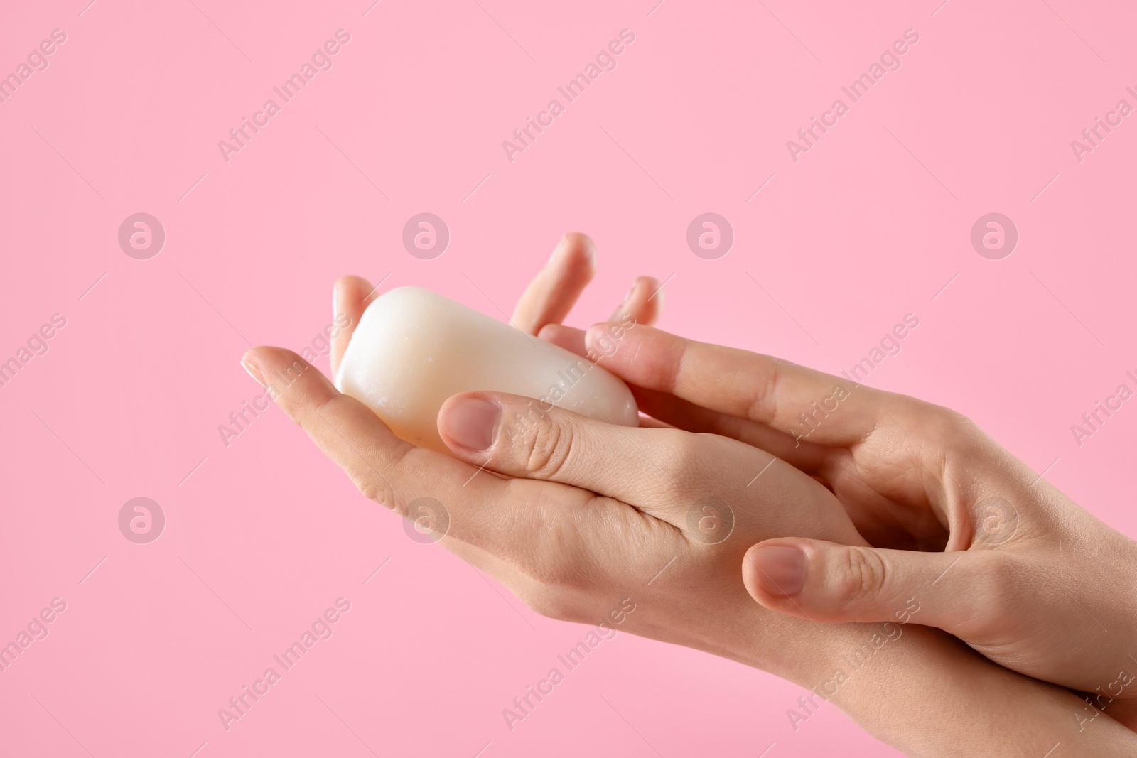 Woman with soap bar on light pink background, closeup Photo of Woman with soap bar on light pink background, closeup