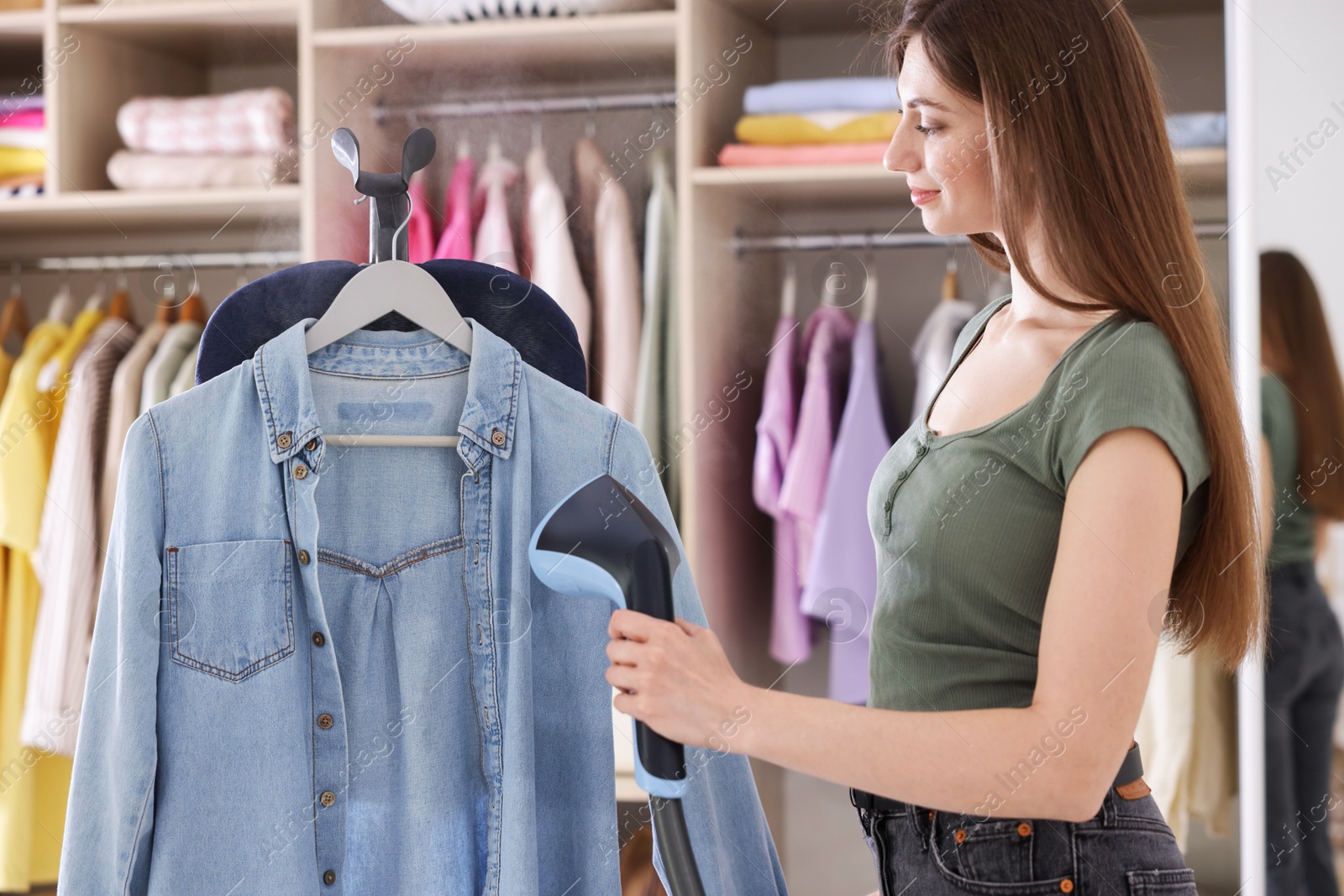 Woman steaming shirt on stand at home Photo of Woman steaming shirt on stand at home