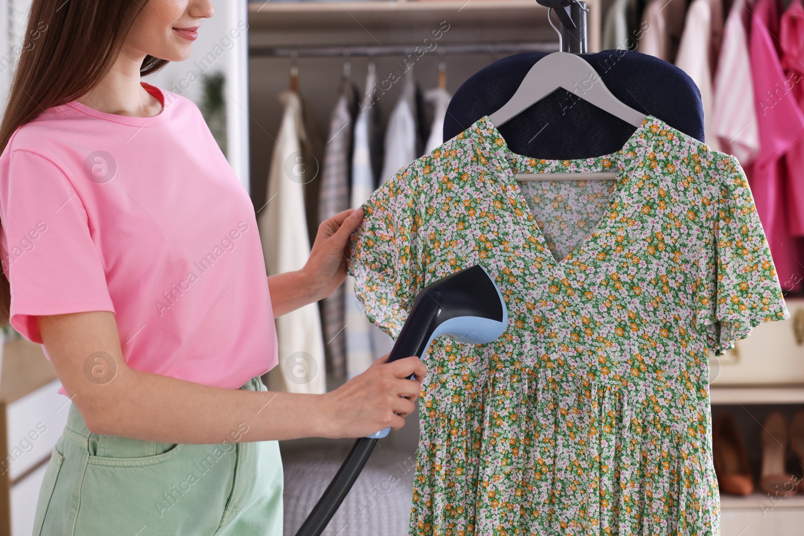 Woman steaming dress on stand at home, closeup Photo of Woman steaming dress on stand at home, closeup