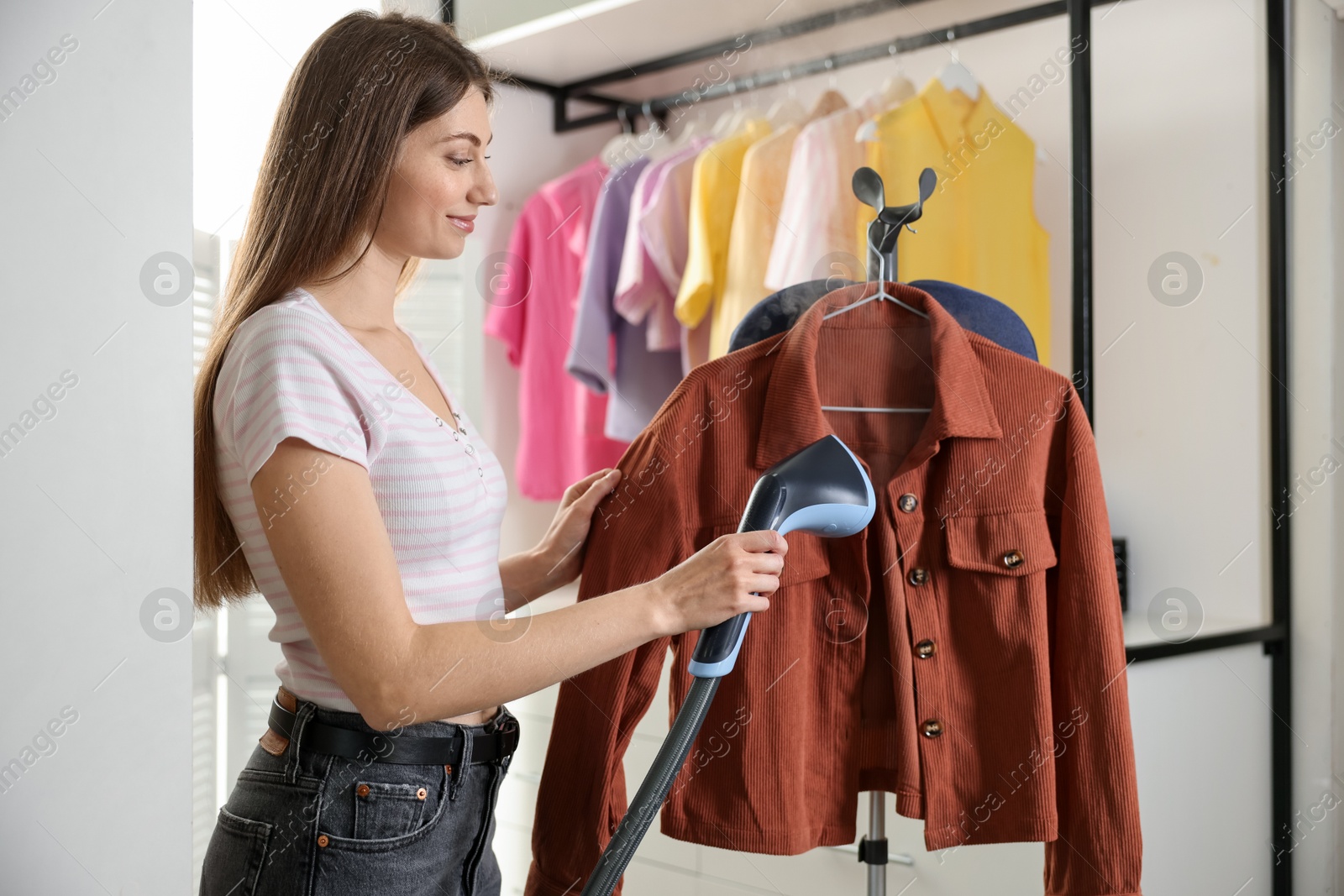 Woman steaming shirt on stand at home Photo of Woman steaming shirt on stand at home