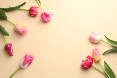 Photo of Beautiful tulips on beige background, flat lay. Space for text