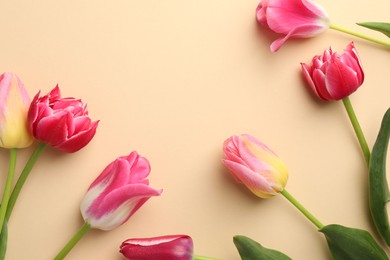 Photo of Beautiful tulips on beige background, flat lay. Space for text