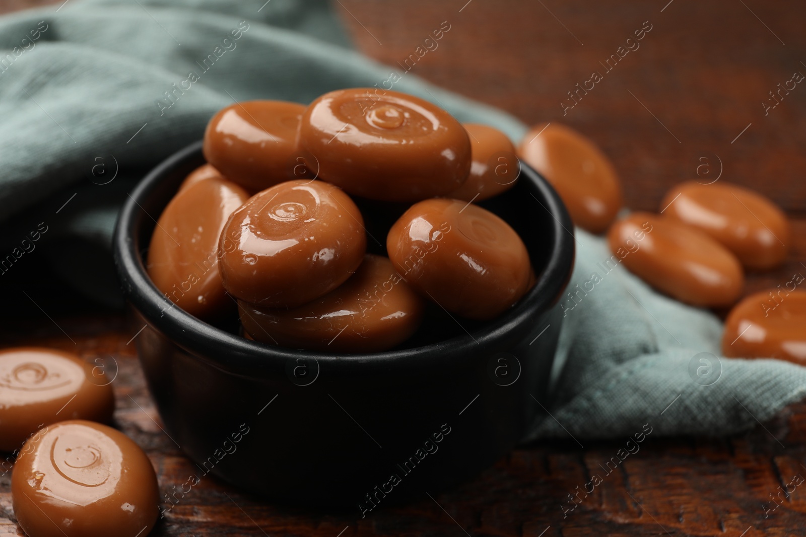 Many tasty caramel candies on wooden table, closeup Photo of Many tasty caramel candies on wooden table, closeup
