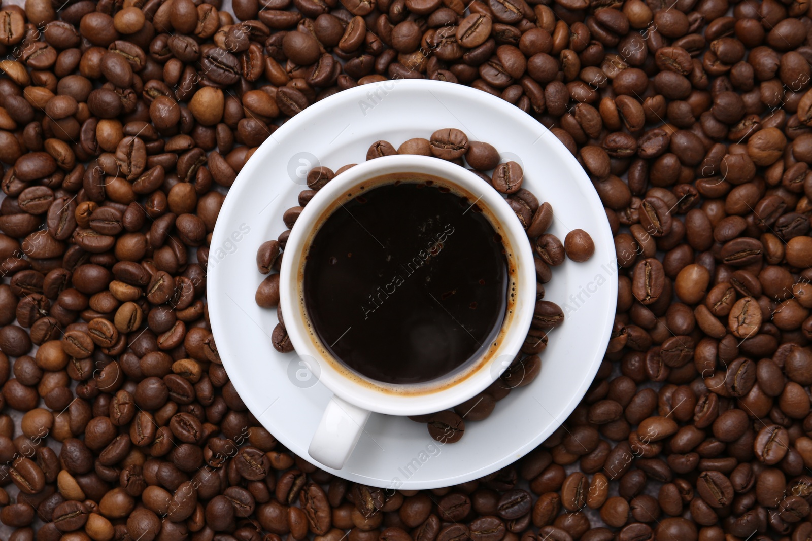 Aromatic coffee in cup, saucer and beans, top view Photo of Aromatic coffee in cup, saucer and beans, top view