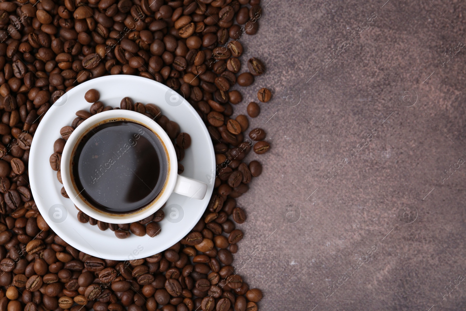 Aromatic coffee in cup, saucer and beans on brown textured table, flat lay. Space for text Photo of Aromatic coffee in cup, saucer and beans on brown textured table, flat lay. Space for text