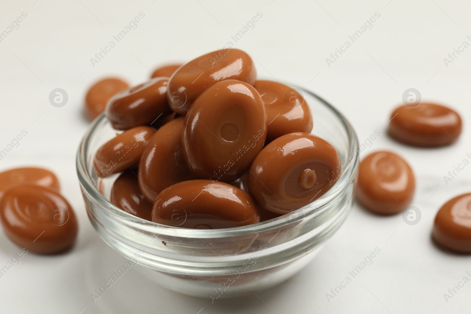 Many tasty caramel candies on white table, closeup Photo of Many tasty caramel candies on white table, closeup