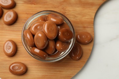 Photo of Many tasty caramel candies on white table, flat lay