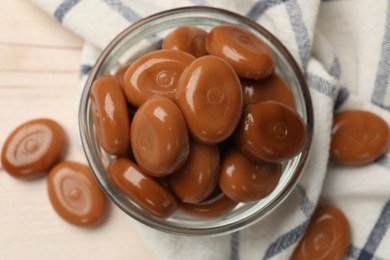 Photo of Many tasty caramel candies on white wooden table, flat lay