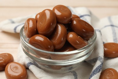 Photo of Many tasty caramel candies on white wooden table, closeup