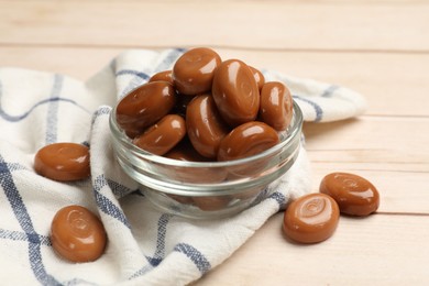 Photo of Many tasty caramel candies on white wooden table, closeup