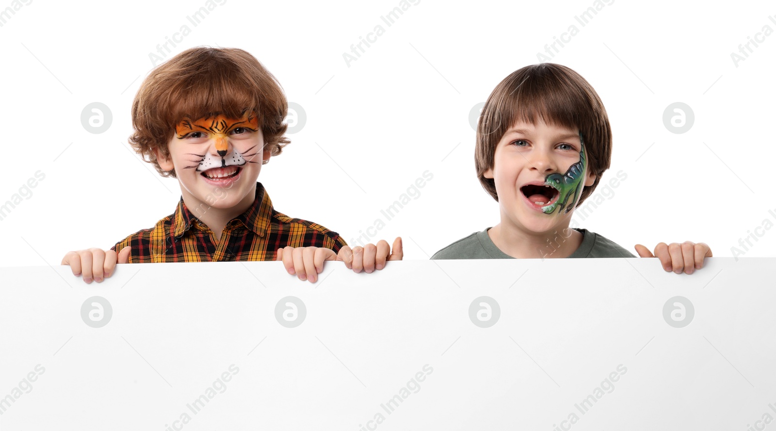 Cute boys with colorful face paintings and blank banner on white background Photo of Cute boys with colorful face paintings and blank banner on white background