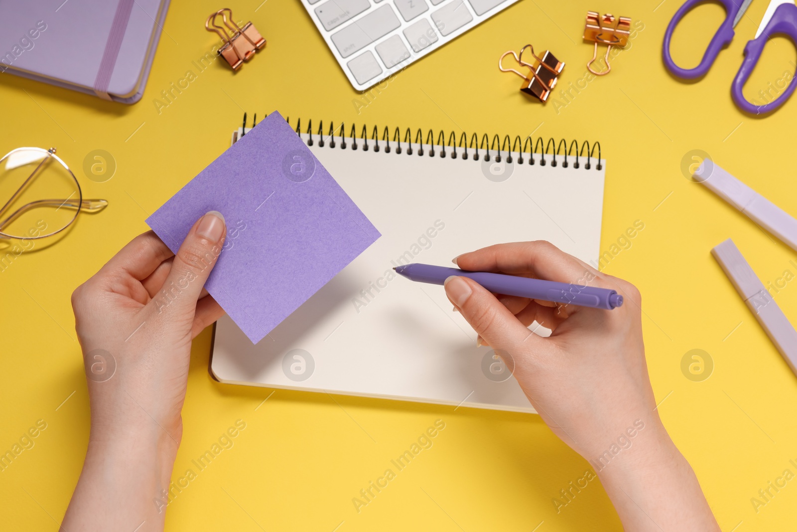 Woman with planner and stationery on yellow background, top view Photo of Woman with planner and stationery on yellow background, top view