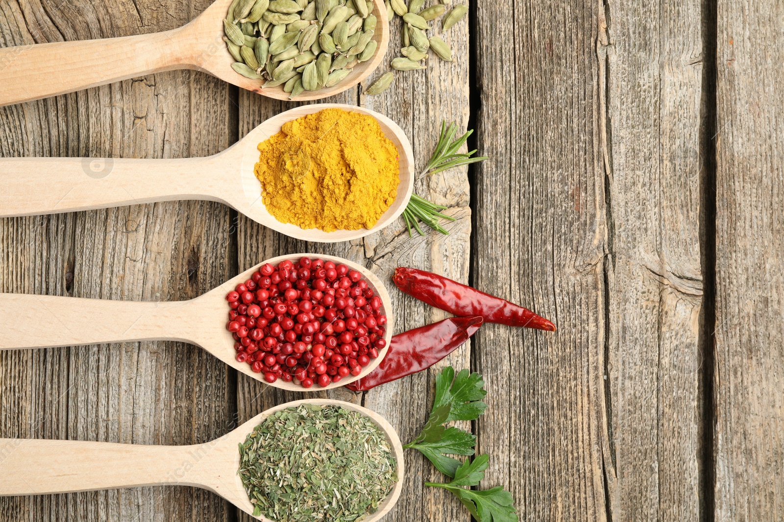 Different aromatic spices in spoons on wooden table, flat lay. Space for text Photo of Different aromatic spices in spoons on wooden table, flat lay. Space for text