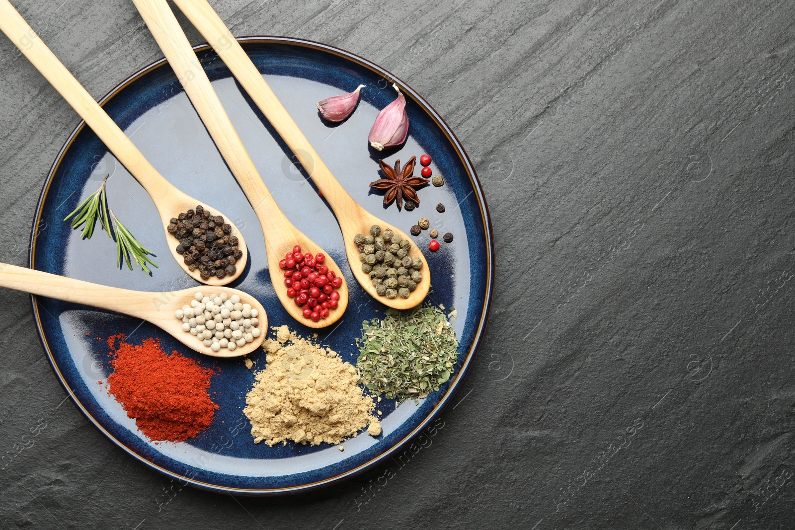 Different aromatic spices in spoons on black table, top view. Space for text Photo of Different aromatic spices in spoons on black table, top view. Space for text
