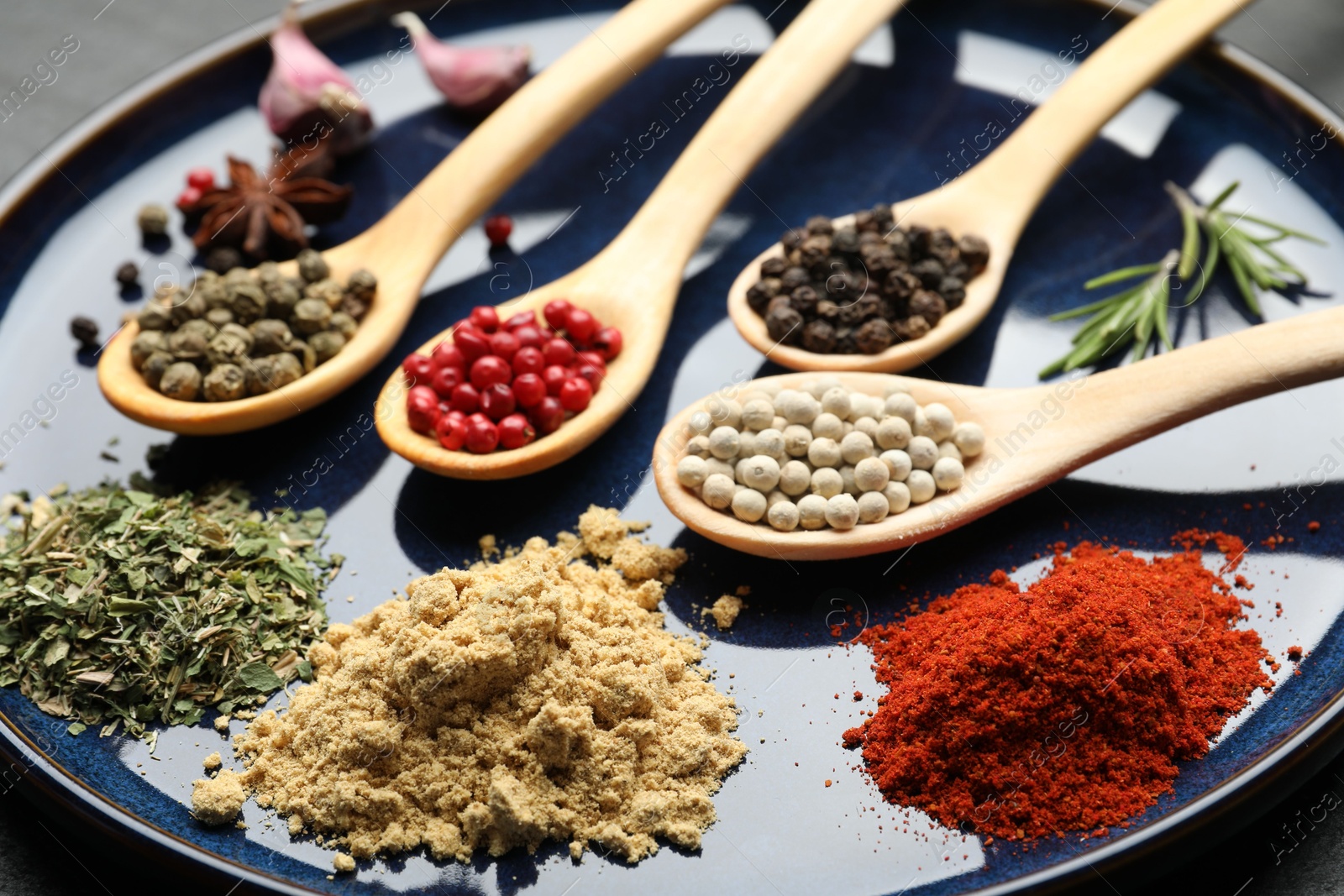 Different aromatic spices in spoons on plate, closeup Photo of Different aromatic spices in spoons on plate, closeup